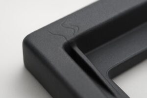 Macro photo showing jetting marks near a gate and flash along a parting line on an injection-molded part